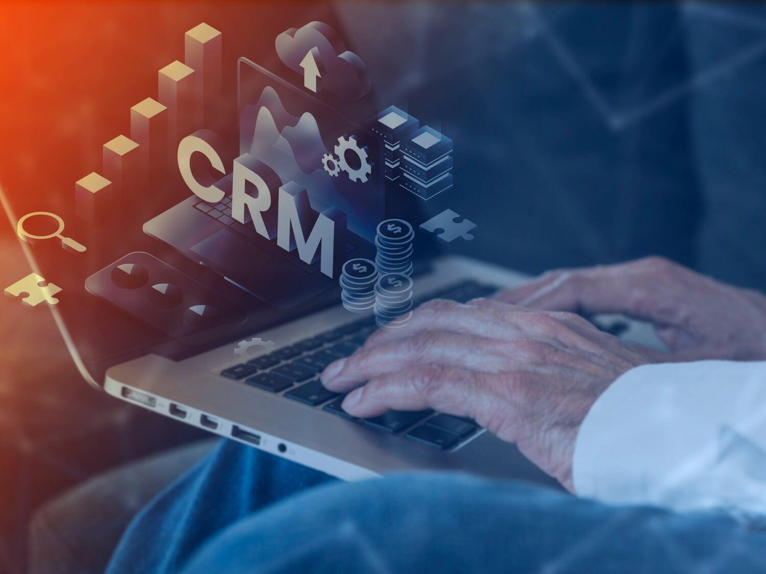 Mãos digitando em notebook com ícones gráficos representando sistema CRM e pipeline de vendas