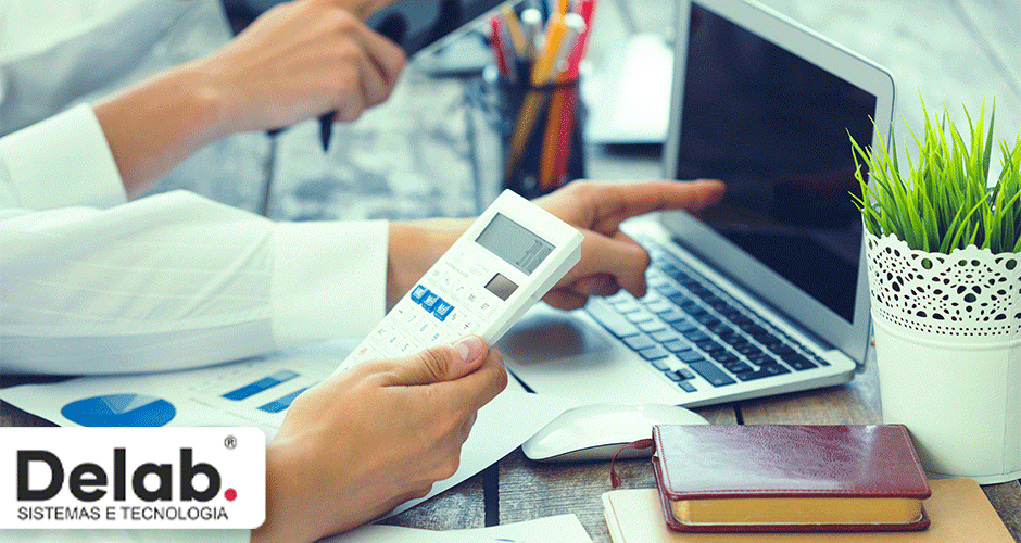 Profissionais utilizando calculadora e laptop com gráficos financeiros na mesa de trabalho